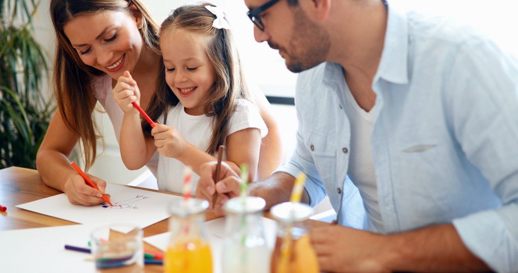 Mom and dad drawing with their daughter